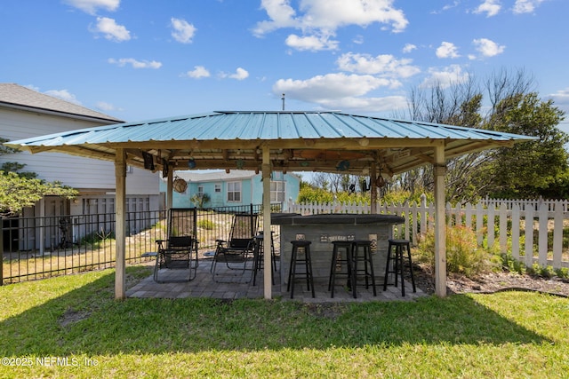view of yard featuring a gazebo, a fenced backyard, a patio area, and outdoor dry bar