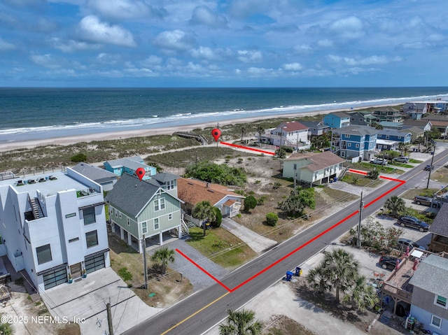 birds eye view of property with a water view and a view of the beach