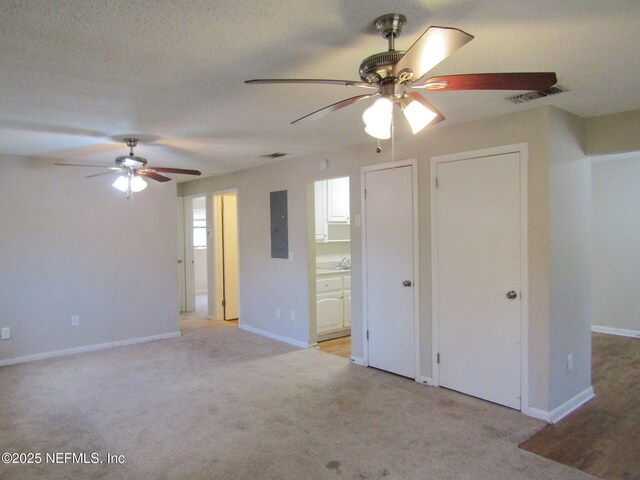interior space featuring baseboards, light carpet, a ceiling fan, and visible vents