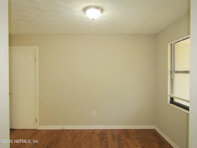 empty room with baseboards and wood finished floors