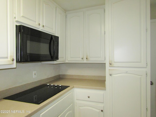 kitchen with light countertops, white cabinetry, and black appliances