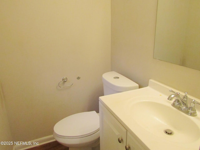 half bathroom with vanity and toilet