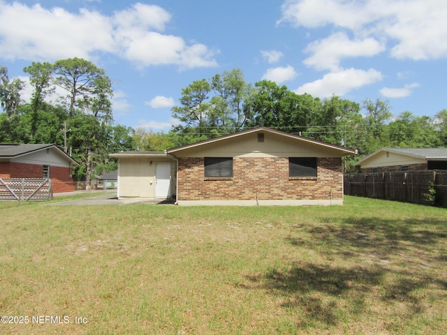 back of house with fence, a lawn, and brick siding