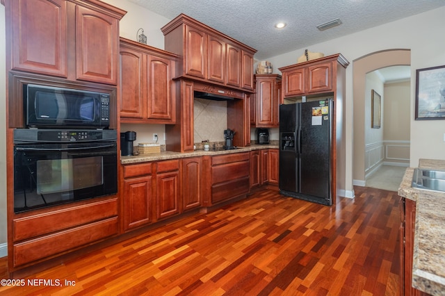 1296 Copper Creek Dr, Macclenny, FL 32063 - kitchen featuring a textured ceiling, black appliances, visible vents, dark wood finished floors, and arched walkways