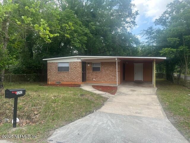 3262 Dignan St, Jacksonville, FL 32254 - ranch-style house with brick siding, fence, an attached carport, and concrete driveway