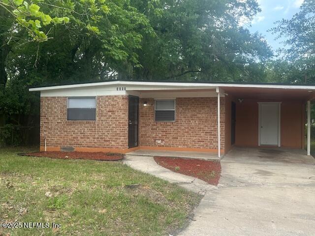 3262 Dignan St, Jacksonville, FL 32254 - single story home featuring a carport, concrete driveway, and brick siding