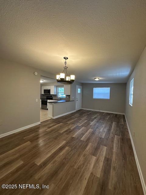 3262 Dignan St, Jacksonville, FL 32254 - unfurnished dining area featuring an inviting chandelier, a textured ceiling, dark wood finished floors, and baseboards