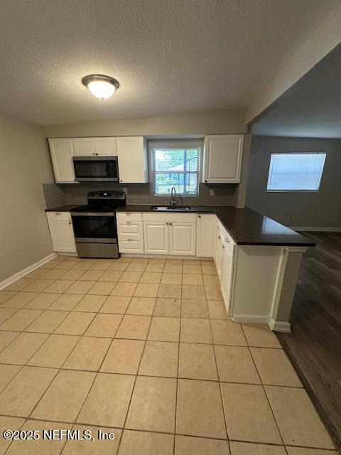 3262 Dignan St, Jacksonville, FL 32254 - kitchen featuring a sink, appliances with stainless steel finishes, a peninsula, and dark countertops