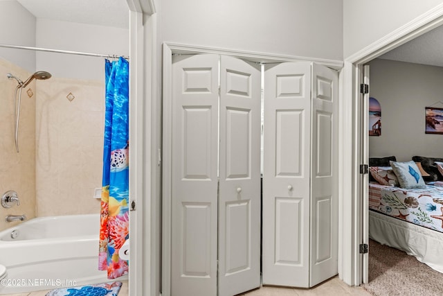 ensuite bathroom featuring shower / tub combo and a closet