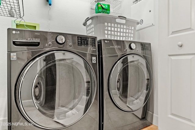 laundry area featuring washer and clothes dryer and tile patterned flooring
