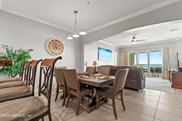 dining space featuring a textured ceiling, crown molding, light tile patterned floors, ceiling fan, and arched walkways