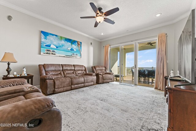 living area with ceiling fan, a textured ceiling, ornamental molding, recessed lighting, and carpet