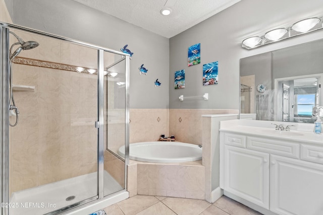 full bath with a stall shower, tile patterned flooring, a garden tub, vanity, and a textured ceiling