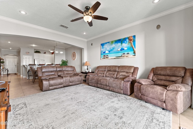 tiled living room featuring ceiling fan, recessed lighting, ornamental molding, and a textured ceiling