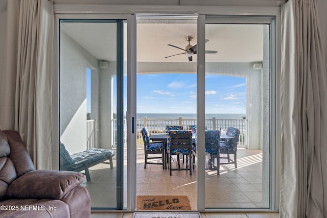 doorway to outside featuring a water view and a ceiling fan