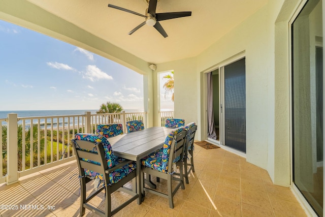 balcony with a water view, a ceiling fan, and outdoor dining area