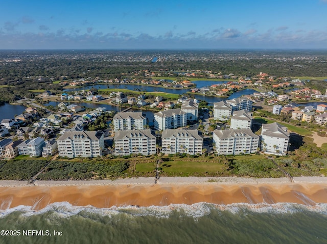 drone / aerial view of waterfront with a beach and apartment complex / building