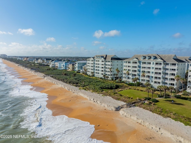 bird's eye view of waterfront with a beach and apartment complex