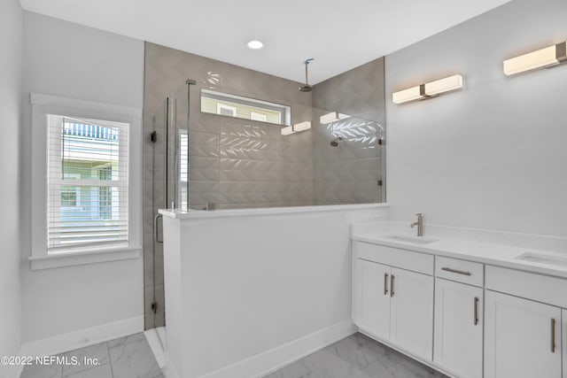 bathroom with baseboards, tiled shower, a sink, and marble finish floor