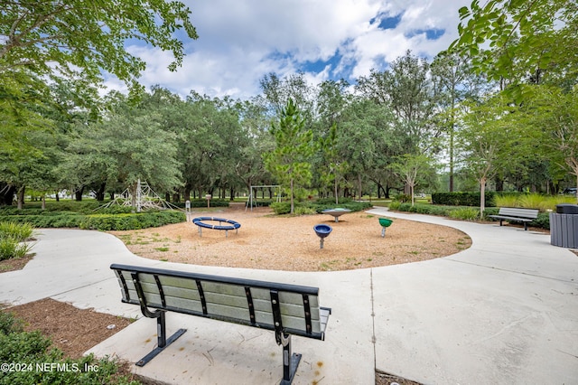 view of home's community with a fire pit and playground community
