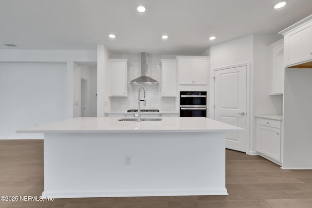 37 Bird Watch Ct, Saint Augustine, FL 32092 - kitchen featuring wall chimney exhaust hood, multiple ovens, backsplash, white cabinetry, and recessed lighting