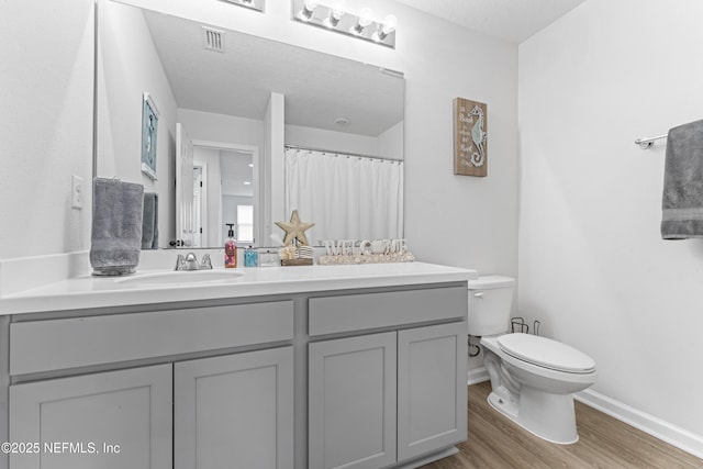 513 Sandstone Dr, Saint Augustine, FL 32086 - full bath featuring visible vents, wood finished floors, vanity, baseboards, and toilet