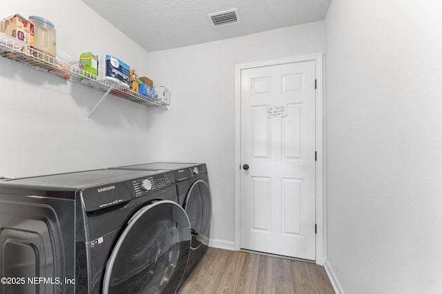 513 Sandstone Dr, Saint Augustine, FL 32086 - clothes washing area featuring laundry area, visible vents, wood finished floors, baseboards, and independent washer and dryer