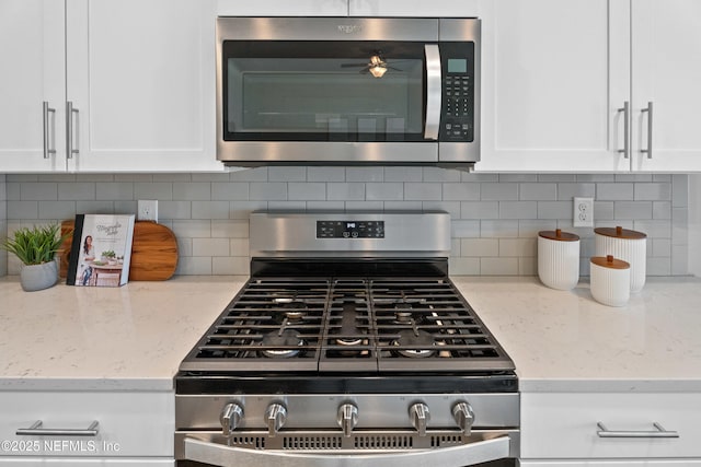 79 Dovetail Cir, Saint Augustine, FL 32095 - kitchen featuring appliances with stainless steel finishes, white cabinets, light stone countertops, and tasteful backsplash