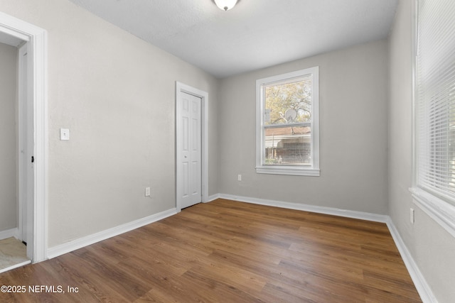 1573 W 16th St, Jacksonville, FL 32209 - unfurnished bedroom featuring baseboards, a closet, and wood finished floors