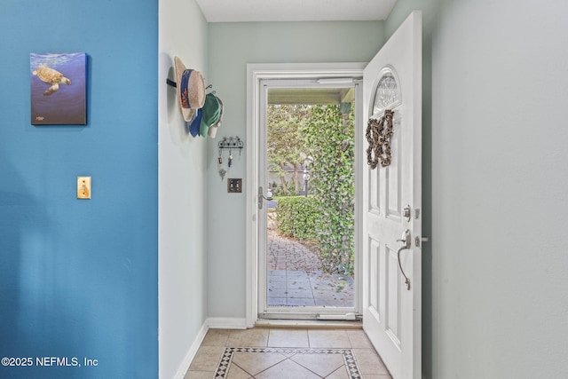 foyer entrance featuring baseboards and light tile patterned floors