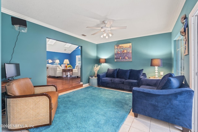 living room with visible vents, a ceiling fan, tile patterned floors, and ornamental molding
