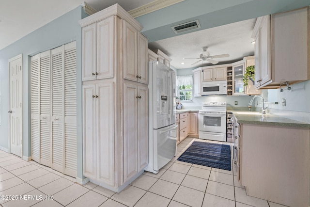 kitchen featuring a sink, white appliances, a ceiling fan, light tile patterned floors, and visible vents