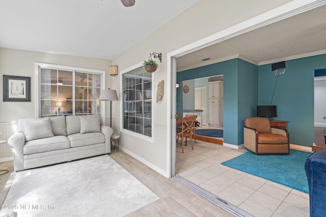 living area featuring baseboards, ornamental molding, and wood finished floors