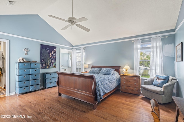 bedroom with high vaulted ceiling, ceiling fan, wood finished floors, and visible vents