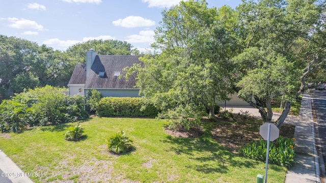 exterior space with a chimney and a front yard