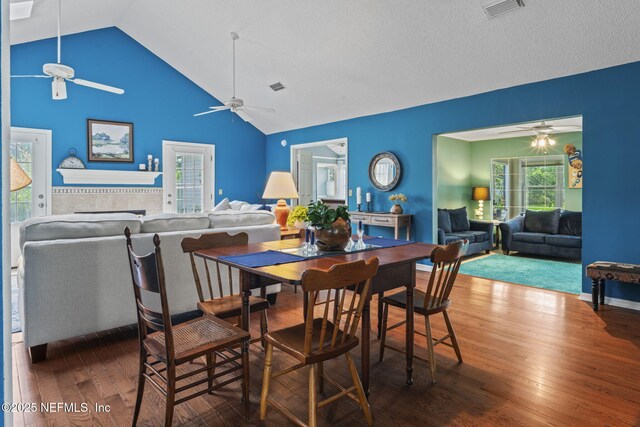 dining space with ceiling fan, visible vents, hardwood / wood-style flooring, and high vaulted ceiling