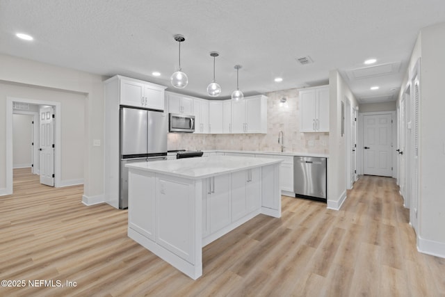 10856 Hawaii Dr S, Jacksonville, FL 32246 - kitchen with light wood-style floors, decorative backsplash, appliances with stainless steel finishes, and white cabinets