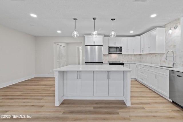 10856 Hawaii Dr S, Jacksonville, FL 32246 - kitchen with backsplash, appliances with stainless steel finishes, a center island, a sink, and white cabinets