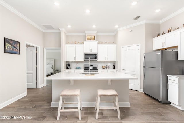 53 Dovetail Cir, Saint Augustine, FL 32095 - kitchen featuring visible vents, decorative backsplash, an island with sink, a sink, and appliances with stainless steel finishes