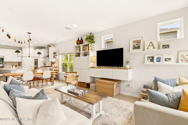 living area featuring visible vents, recessed lighting, and baseboards