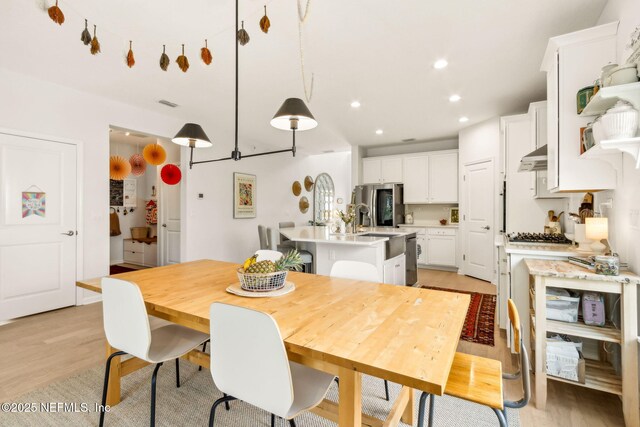 dining area featuring recessed lighting and light wood-style flooring