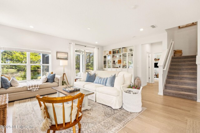 living area featuring light wood-style floors, recessed lighting, stairs, and visible vents