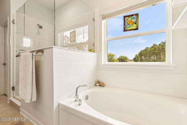 bathroom featuring a garden tub, tile patterned floors, and a tile shower