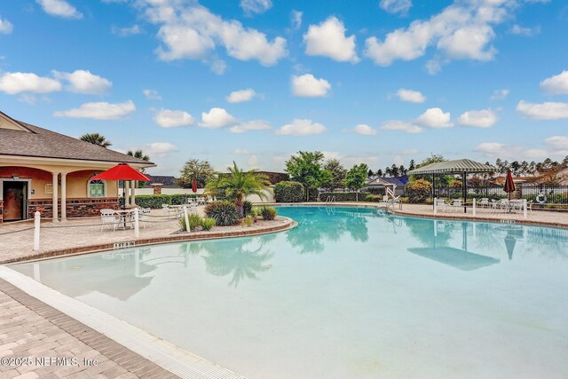 pool with fence, a gazebo, and a patio area