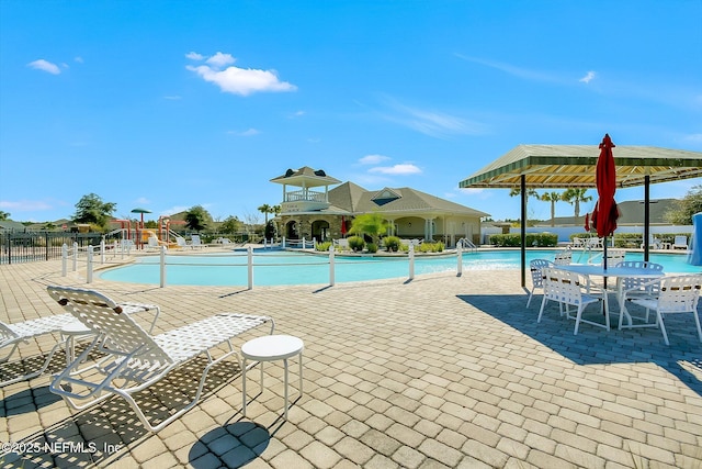 pool featuring fence and a patio area