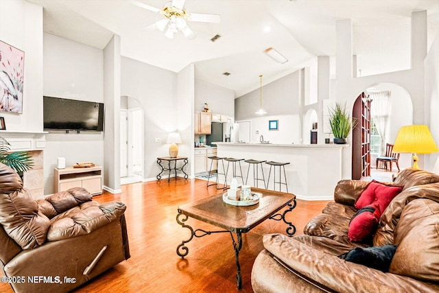 1105 Pine Mill Ln, Ponte Vedra Beach, FL 32082 - living area with arched walkways, high vaulted ceiling, a ceiling fan, light wood-type flooring, and baseboards