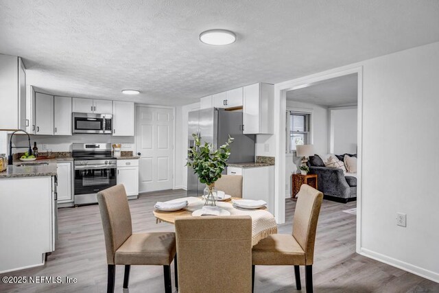 1059 Little Ruth Rd, Green Cove Springs, FL 32043 - dining area featuring baseboards, a textured ceiling, and light wood finished floors