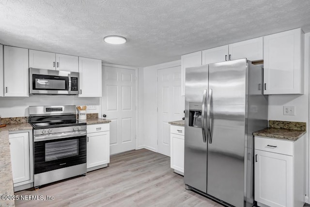 1059 Little Ruth Rd, Green Cove Springs, FL 32043 - kitchen featuring a textured ceiling, light stone counters, white cabinets, light wood finished floors, and stainless steel appliances