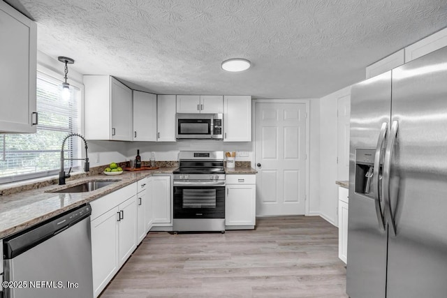 1059 Little Ruth Rd, Green Cove Springs, FL 32043 - kitchen with light stone counters, a sink, appliances with stainless steel finishes, and white cabinets