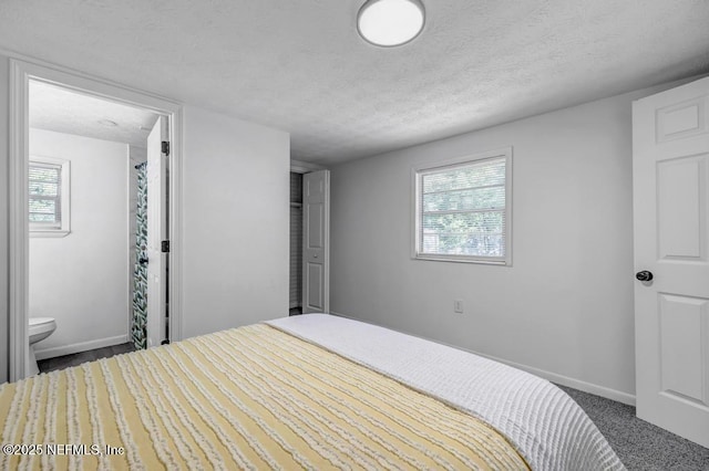 1059 Little Ruth Rd, Green Cove Springs, FL 32043 - bedroom with baseboards, multiple windows, a textured ceiling, and connected bathroom